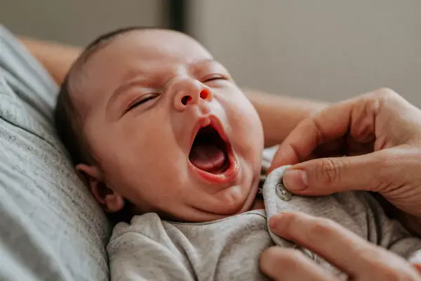 Bebé bostezando, quizás uno de esos despertares nocturnos de un bebé de 1 año.